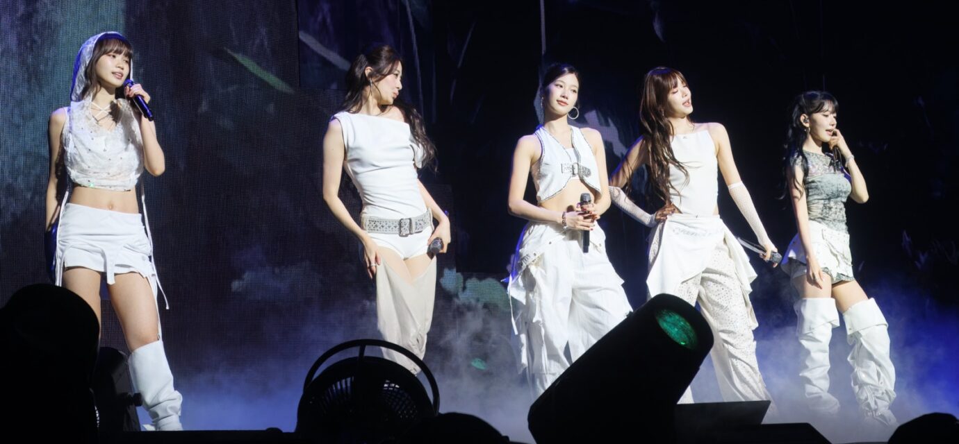 Five members of LE SSERAFIM performing on stage in Seattle in 2025.