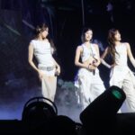Five members of LE SSERAFIM performing on stage in Seattle in 2025.