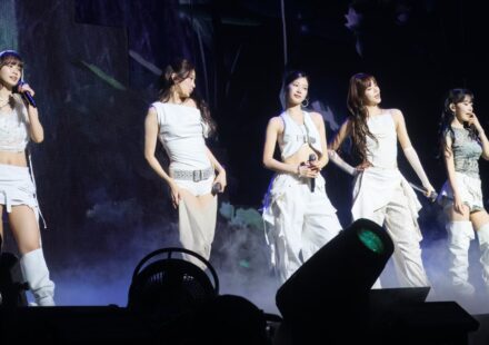 Five members of LE SSERAFIM performing on stage in Seattle in 2025.