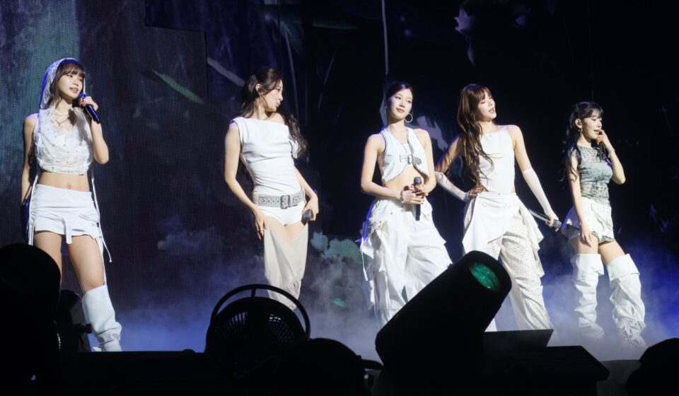 Five members of LE SSERAFIM performing on stage in Seattle in 2025.